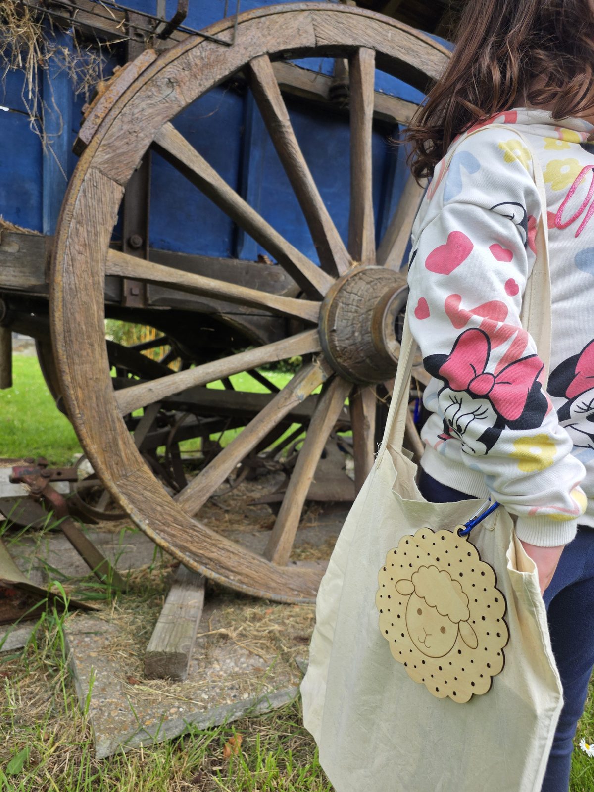 Enfant en balade avec son sac et son tableau mouton Kidiz'plorer dans une ferme